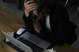 A person sitting alone at a desk stuck in a repetitive overthinking cycle, illustrating why do I think the same thoughts over and over.