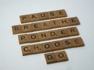 Wooden Scrabble tiles spelling out a mindful behavioral chain to explain why can't I stay consistent with habits long term.