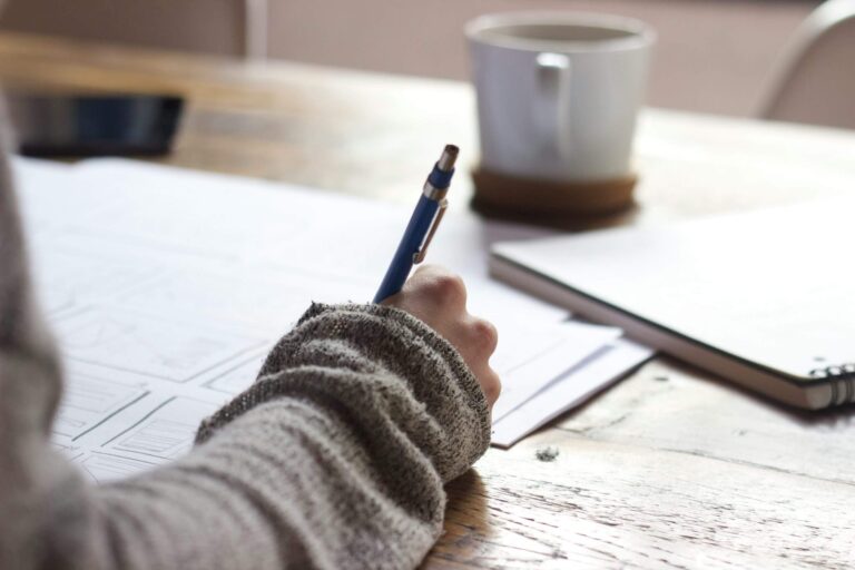 Person journaling in a calm reflective setting for the BetterYouWithin contact page