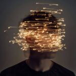 person surrounded by chaotic light trails symbolizing negative thought patterns