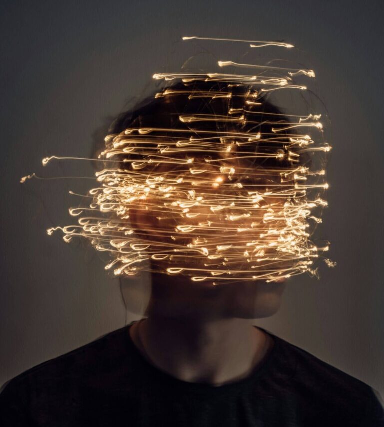 person surrounded by chaotic light trails symbolizing negative thought patterns