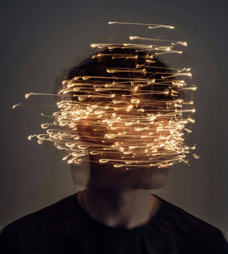 person surrounded by chaotic light trails symbolizing negative thought patterns