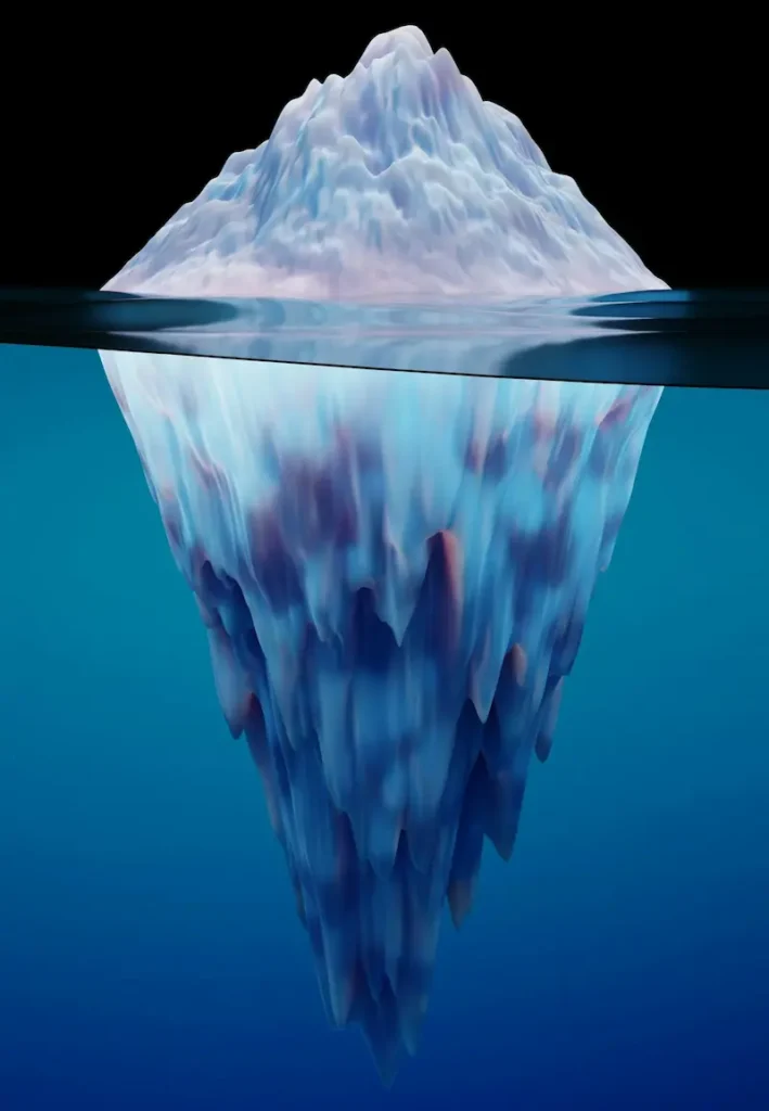 An iceberg floating in deep blue water representing the conscious and subconscious mind.