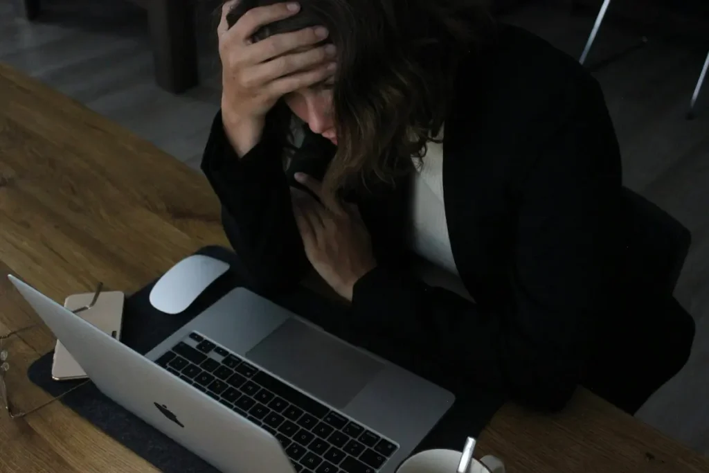 A person sitting alone at a desk stuck in a repetitive overthinking cycle, illustrating why do I think the same thoughts over and over.