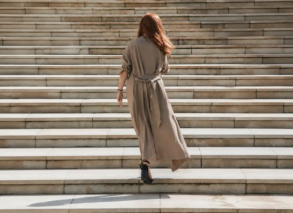 Woman walking up steps, representing identity change and personal growth