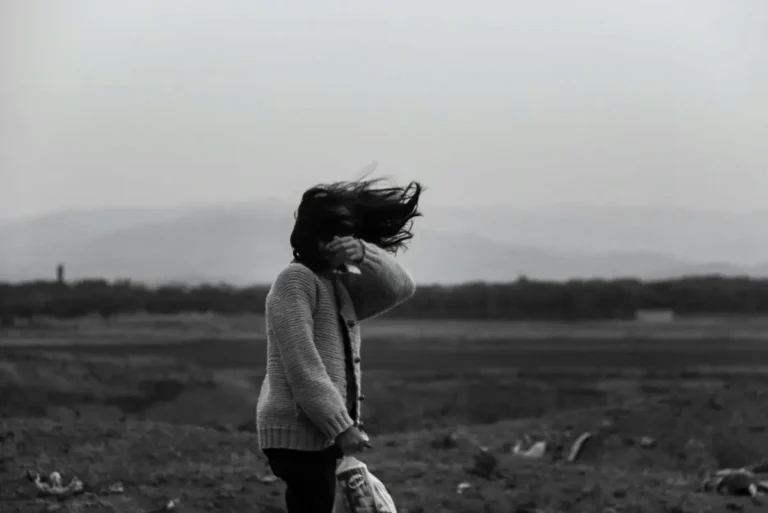 Woman walking through strong wind, representing mental toughness under pressure