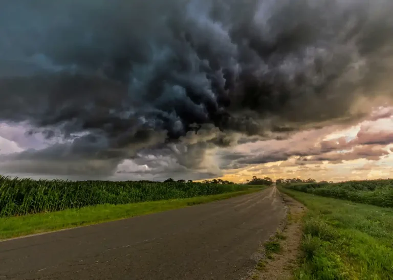 Road beneath dark storm clouds leading toward a brighter sky, representing emotional recovery after a setback