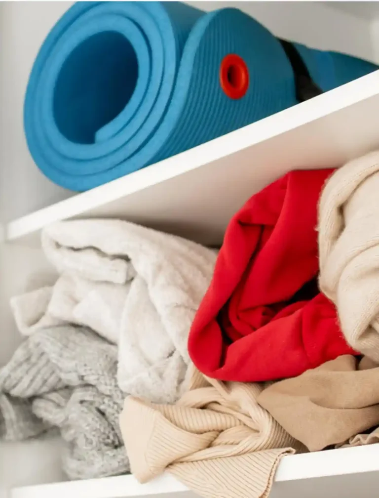 Rolled-up exercise mat stored in a cluttered closet, illustrating behavioral friction