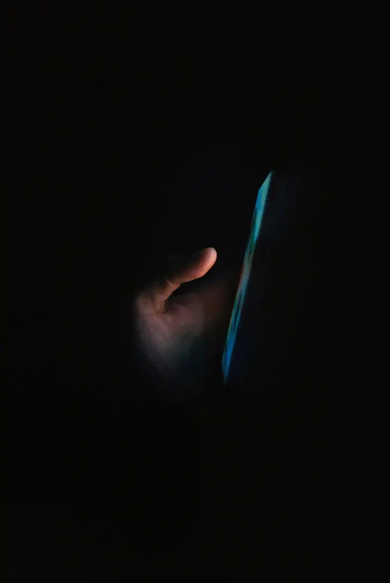 Person using a phone in the dark, representing a broken promise to stop scrolling and go to bed